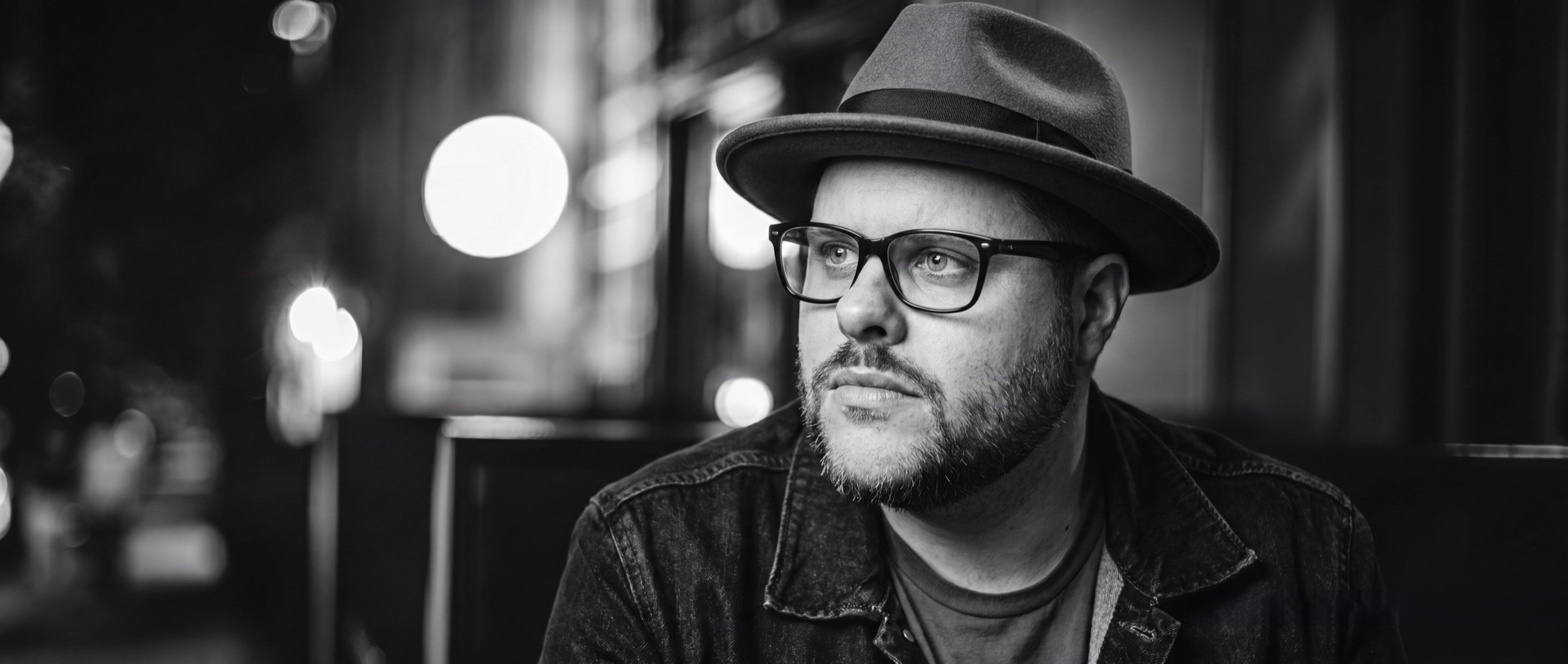 Grant Morriss in a hat and glasses, photographed at night