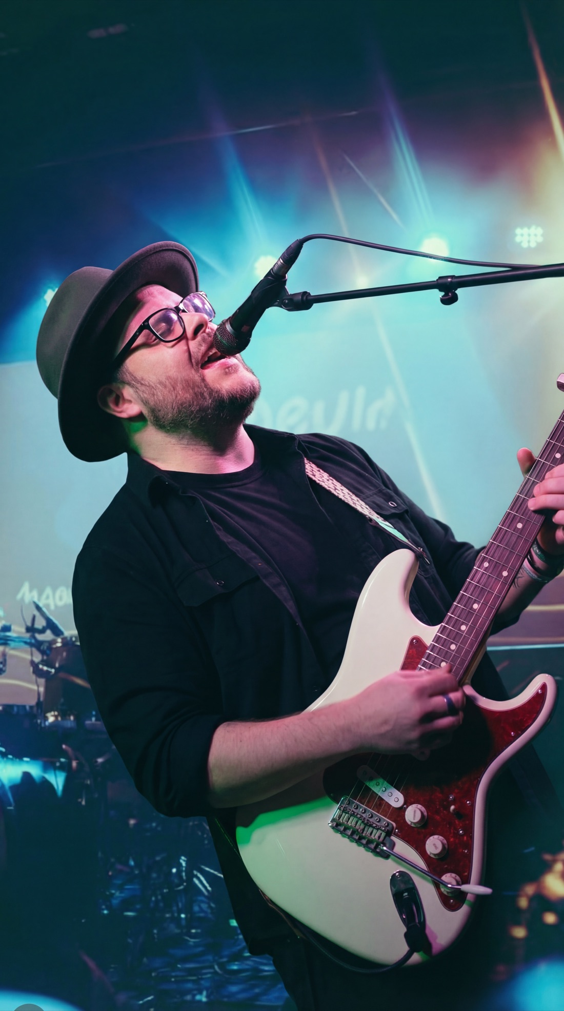 Grant Morriss singing and playing electric guitar on stage